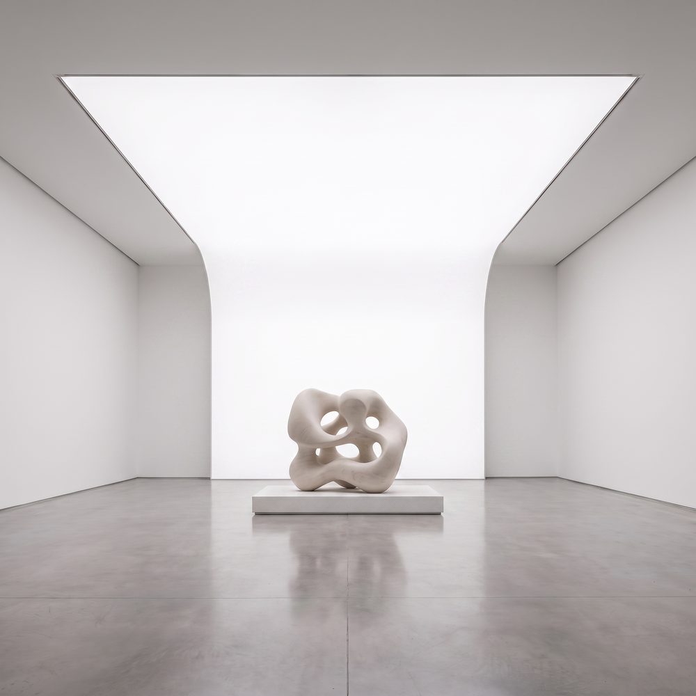Luminous stretch ceiling curving from the ceiling down the wall to the floor in one continuous surface