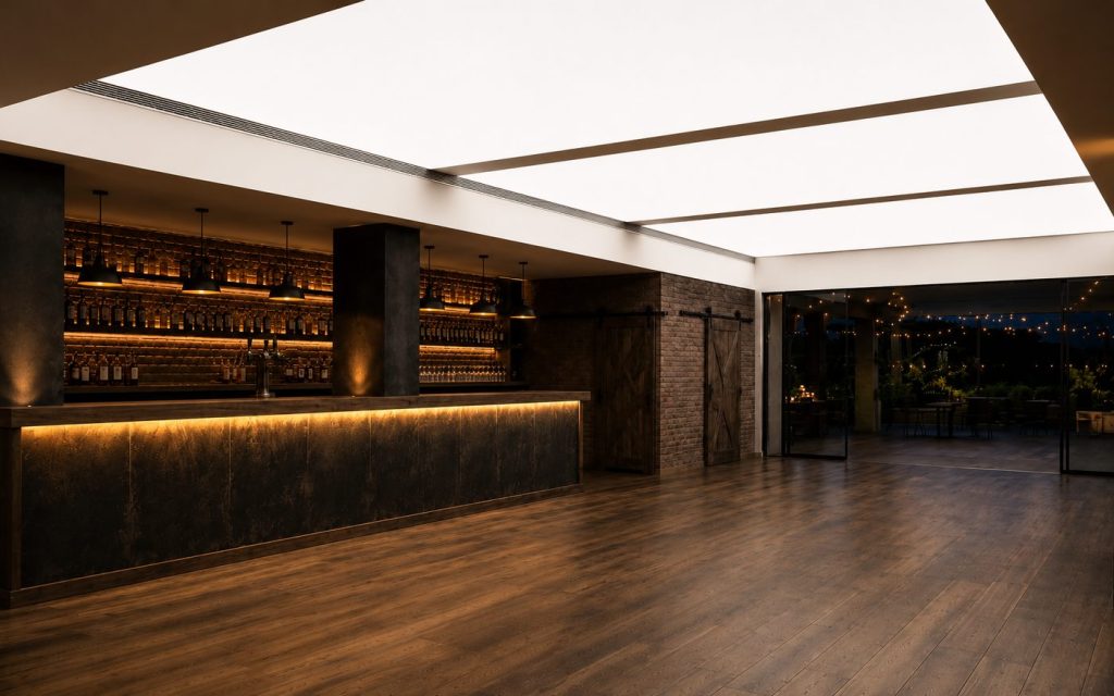 Three luminous ceiling light boxes over a bar with backlit shelving