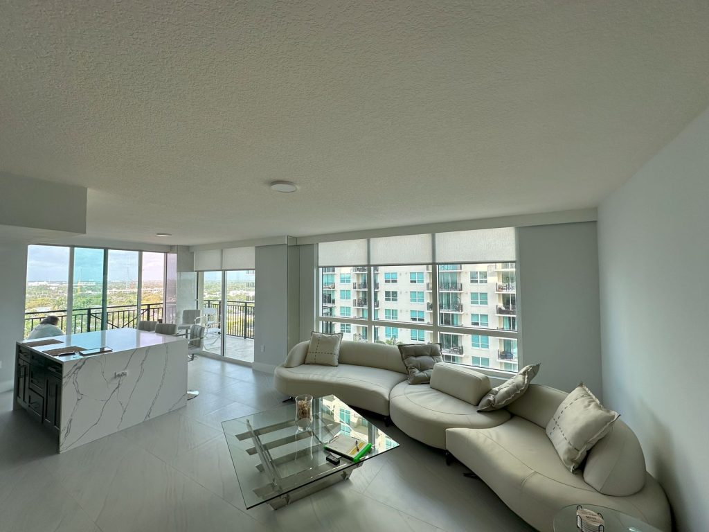Fort Lauderdale condo living room with a textured popcorn ceiling and one flush mount light, before